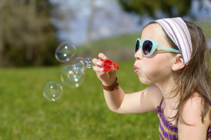 a little girl making soap bubbles